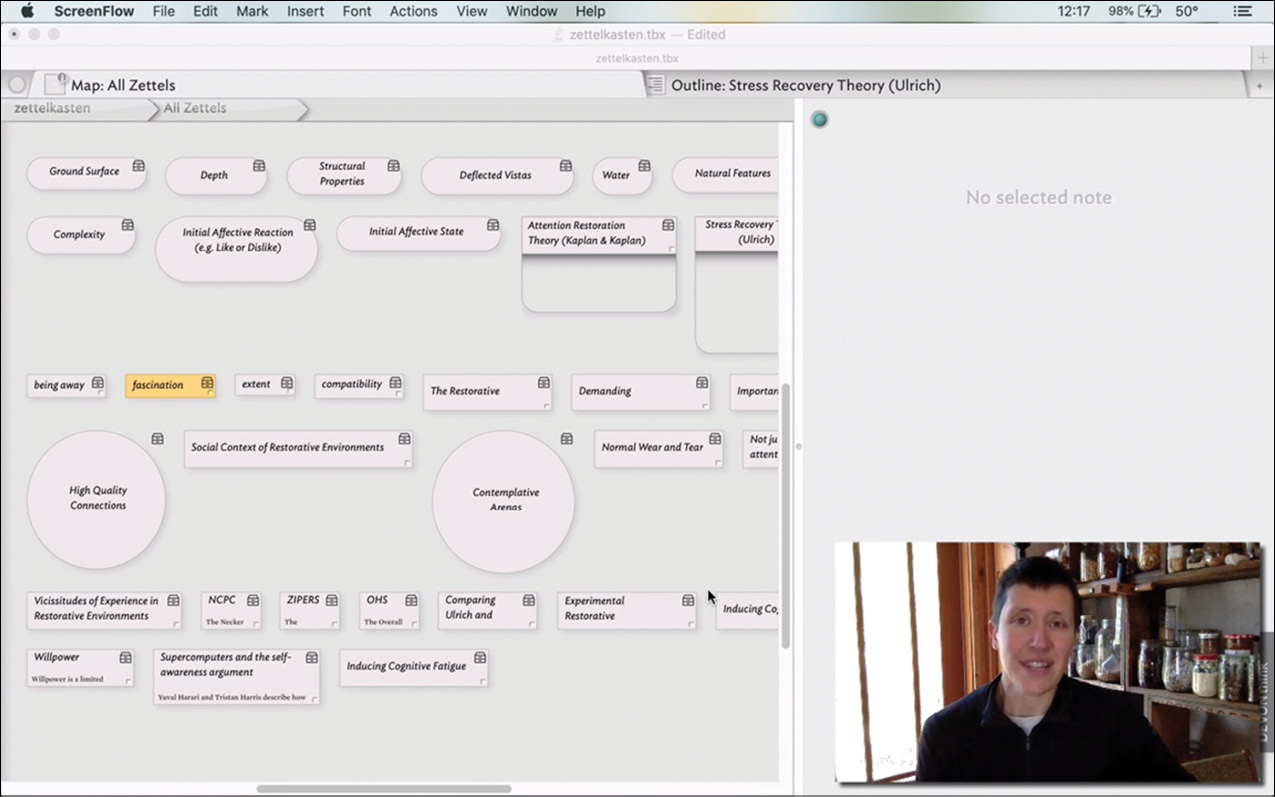Beck Tench YouTube视频中的一个画面。背景显示了一个Tinderbox屏幕，其中有几个代表笔记的形状。前景是Beck解释Tinderbox文档的视频画面。